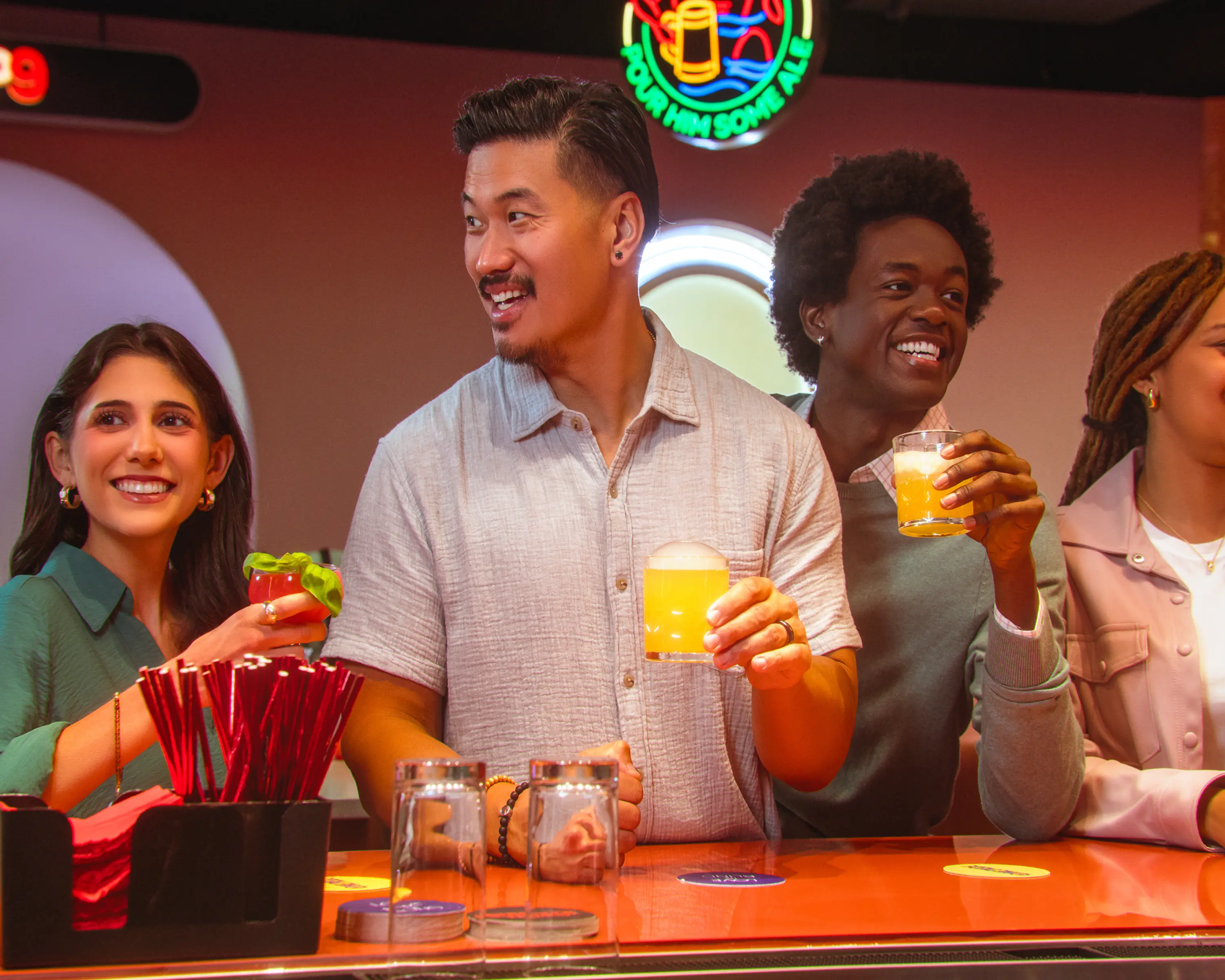 A group of 4 co-workers enjoy cocktails at the Netflix Bites bar.